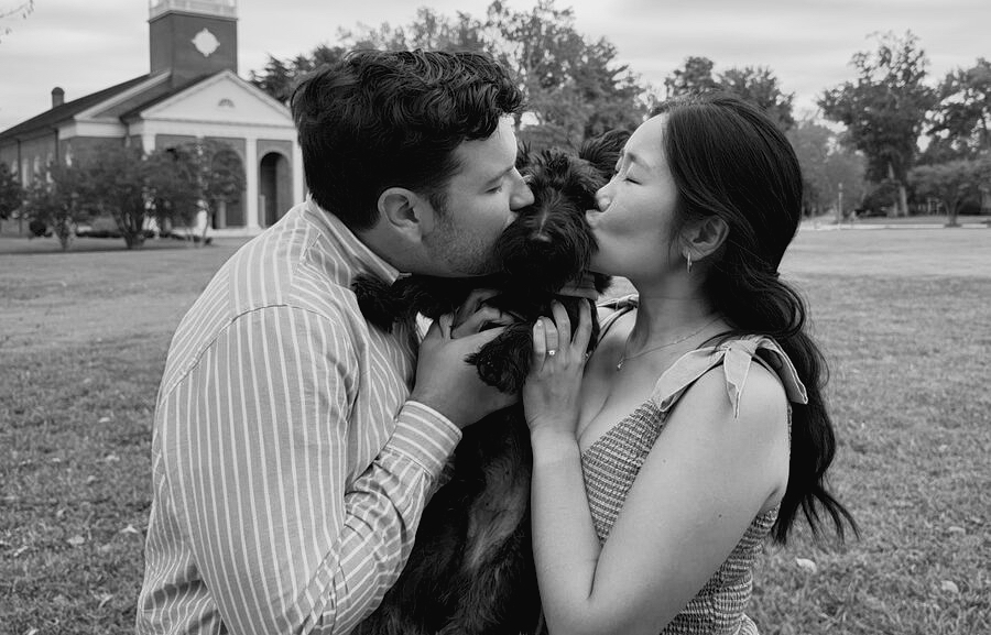 Joy and Michael both kissing their dog